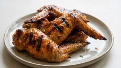 Overhead view of baked Cambodian chicken wings with a glossy sweet and spicy glaze on a baking dish.